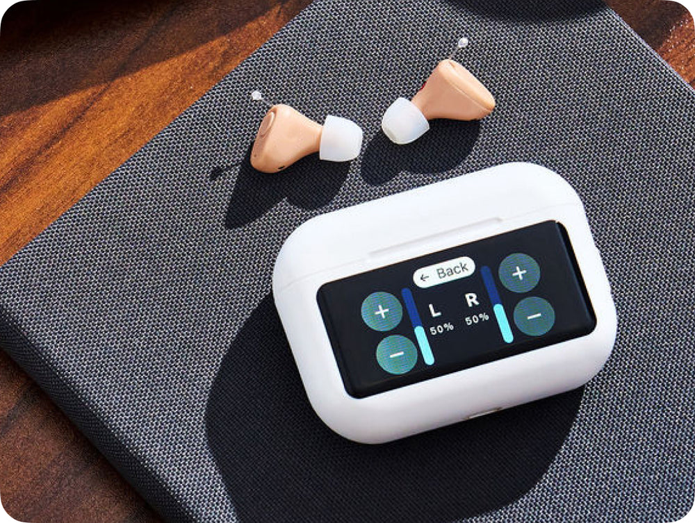 Wireless earbuds with a charging case on a textured surface